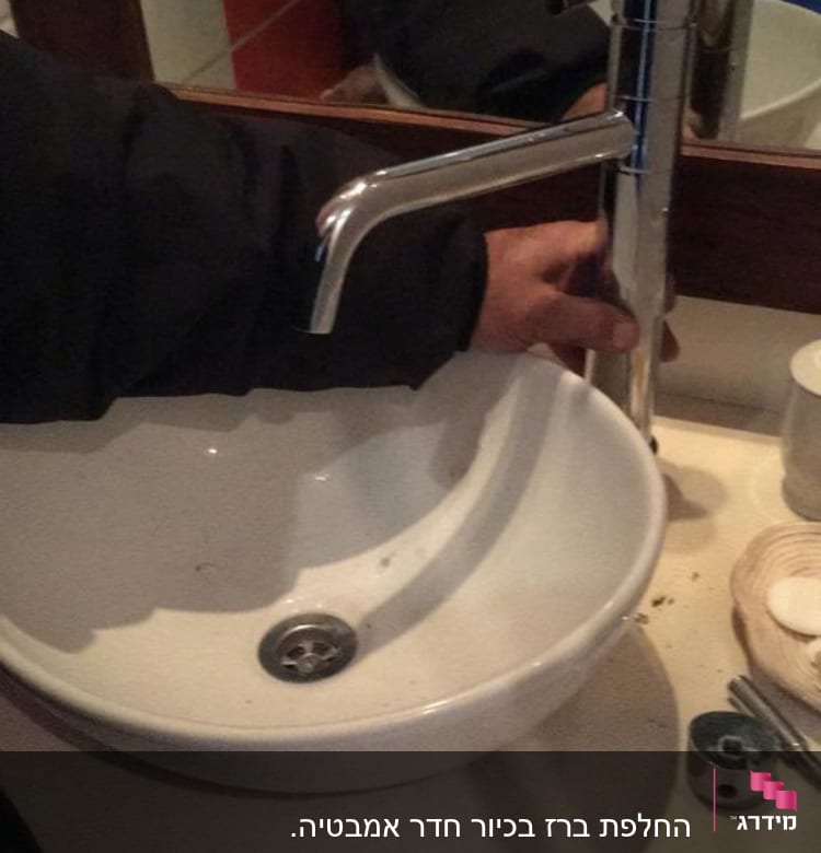 יד מחזיקה ברז מעל כיור עגול